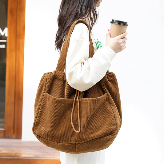 Front view of the women's corduroy drawstring underarm shoulder bag laid flat
